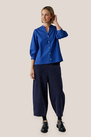 Chemise Dina popeline de coton bleu roi La Sélection Stocks du Marais, portée par Mali en pieds, main dans les cheveux