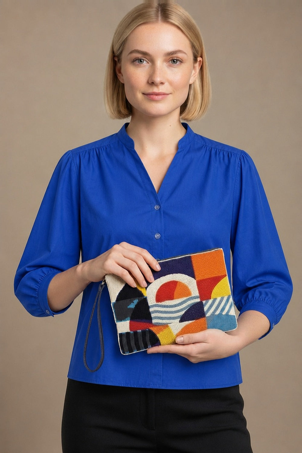 Pochette Jaydi orange perlée portée par la mannequin en chemise Dina bleu roi