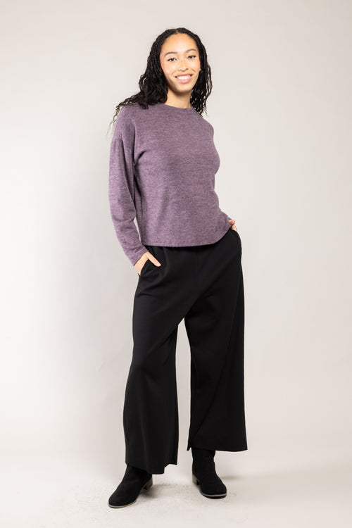 Pantalon Ponny Milano noir a.osher porté avec un pull violet, silhouette complète