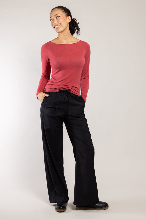 Pantalon Rundu laine écoresponsable noir Elemente Clemente porté avec un top rose, silhouette complète
