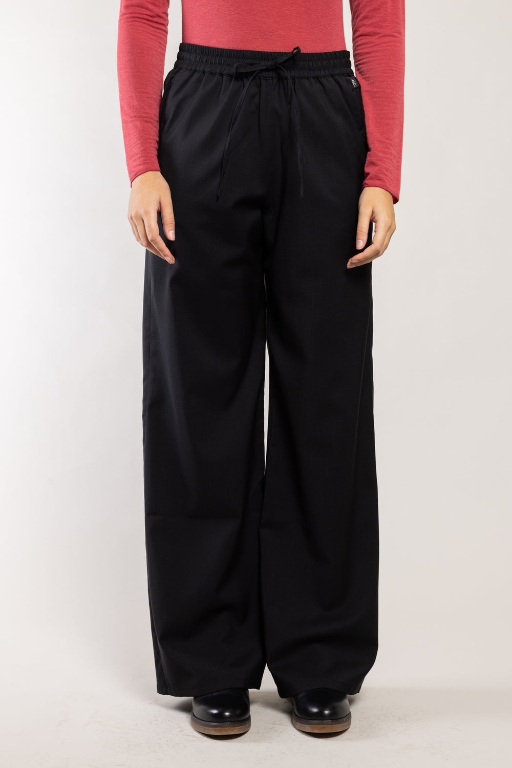 Pantalon Rundu laine écoresponsable noir Elemente Clemente porté avec un top rose, silhouette complète