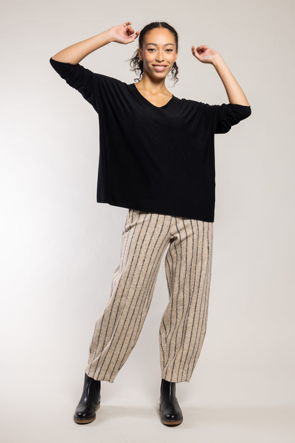 Pantalon Yolo laine bouclette beige Elemente Clemente porté avec un top noir, silhouette complète