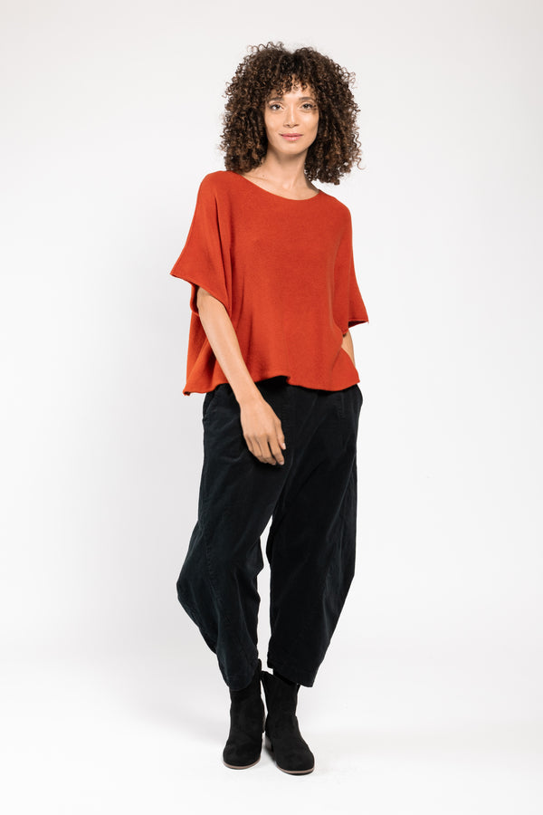 Pull Beli col V orange La Sélection Stocks du Marais, porté sur un pantalon large noir, silhouette en pied