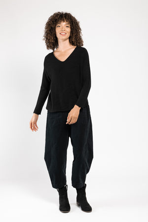 Pull Olivia col V noir La Sélection Stocks du Marais, porté sur un pantalon large noir, silhouette en pied