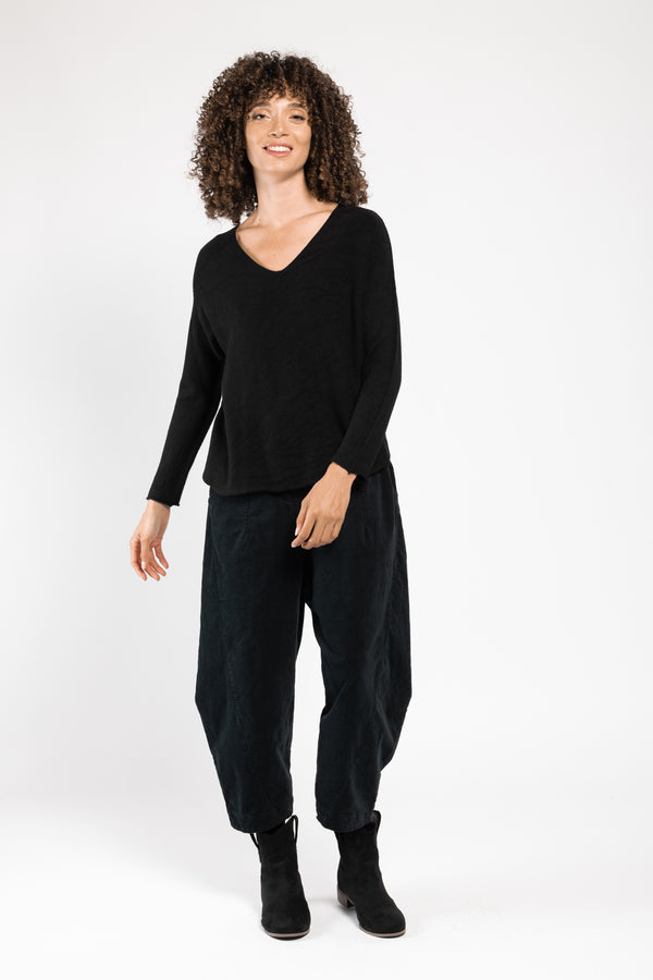Pull Olivia col V noir La Sélection Stocks du Marais, porté sur un pantalon large noir, silhouette en pied