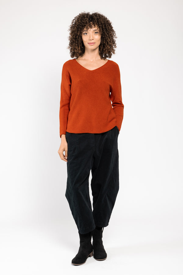 Pull Olivia col V orange La Sélection Stocks du Marais, porté sur un pantalon large noir, silhouette en pied