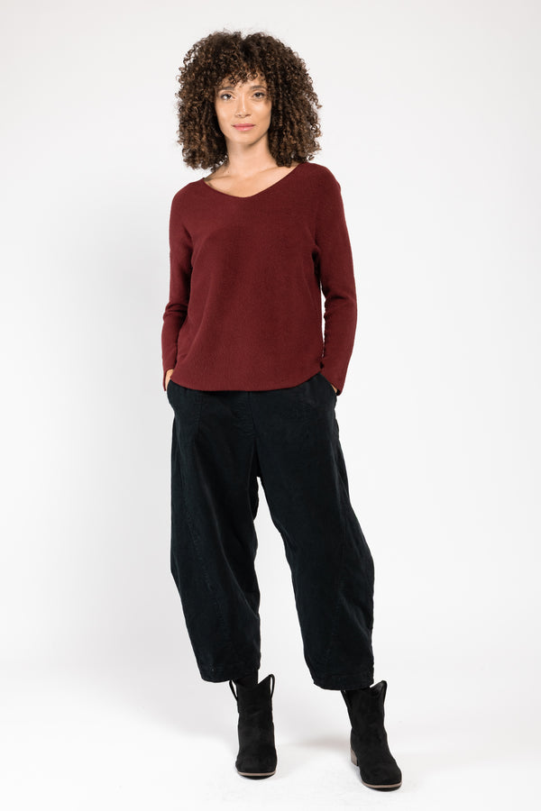 Pull Olivia col V rouge La Sélection Stocks du Marais, porté sur un pantalon large noir, silhouette en pied
