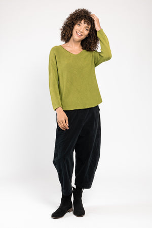 Pull Olivia col V vert La Sélection Stocks du Marais, porté sur un pantalon large noir, silhouette en pied