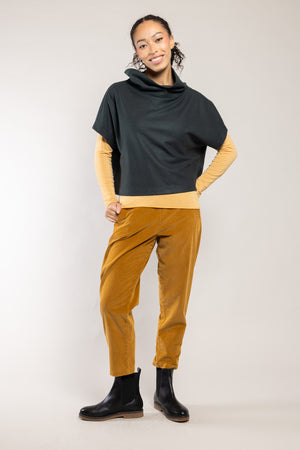 Top Diva laine écoresponsable émeraude Elemente Clemente porté avec le pantalon Geishan doré, silhouette complète